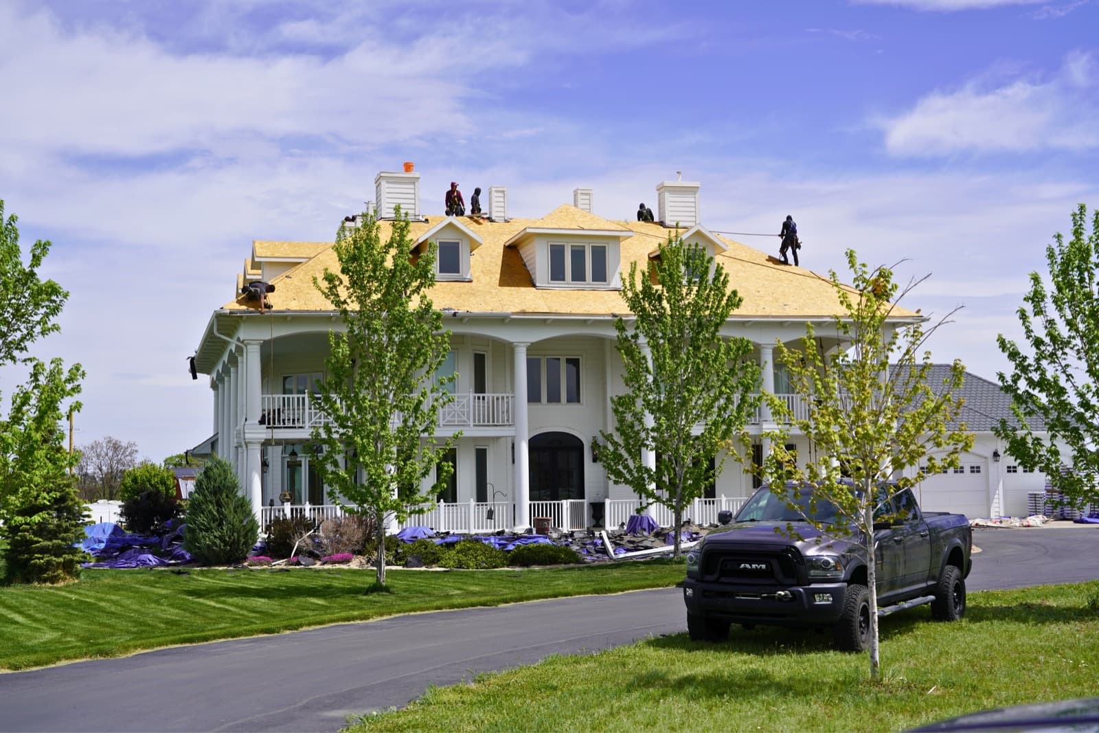Gates Enterprises crew performing a full tear off roof replacement on a large home
