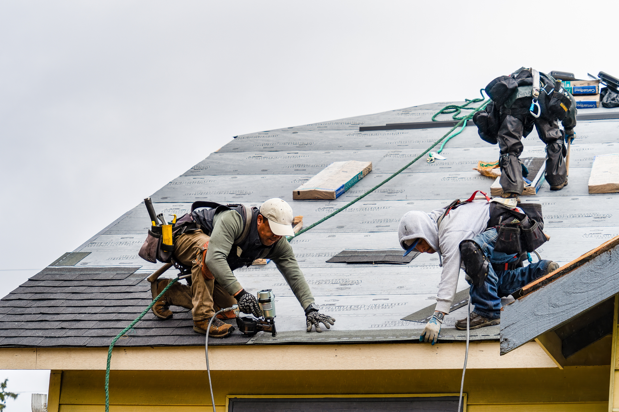 roofers on top of house